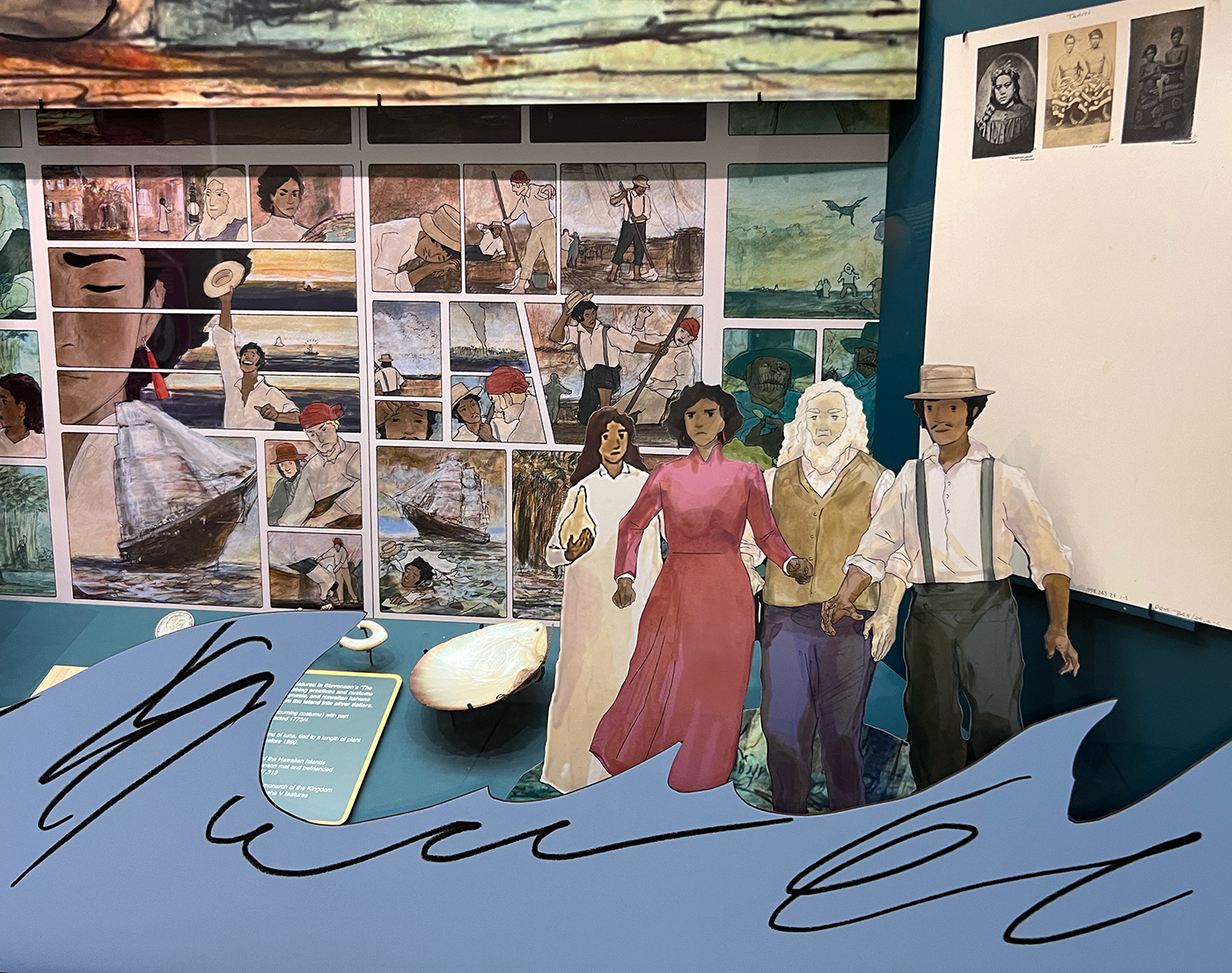 Close up view showing a museum display containing a graphic comic background, cut out illustrated figures, and a wave graphic across the bottom of the case.
